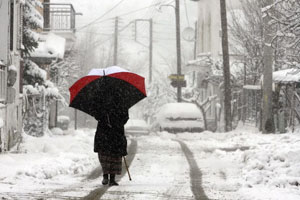 A woman walks in the village of Malakasa, near Athens, Greece, during heavy snowfall on Sunday.