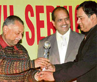 Winner of the 3rd North Zone Civil Services Golf Championship, R.C. Chandra (right) receives a trophy during a prize distribution function at Golf Range in Chandigarh on Sunday.