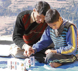A special educator of Sidhi teaches a mentally challenged child by a play-way method in Nahan.