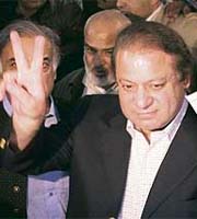 Former prime minister Nawaz Sharif holds up his ballot paper and flashes the victory sign at a polling station in Lahore