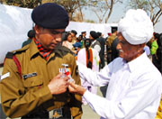 Father of Lance Naik Mahendra Singh Yadav adoring his sons achievement after the investiture ceremony