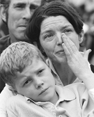 A woman wipes tears from her eyes as she watches Rudd make the apology on a big screen outside Parliament House.