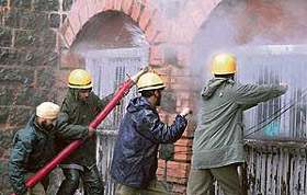 Fire fighters try to put out fire after an accidental explosion in the lower court complex in Srinagar on Friday.