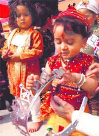 A little girl playing with a crown during the healthy baby show at Ashmah International School in Mohali on Sunday.