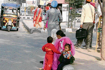 Commuters wait for buses on the Pakhowal road in Ludhiana on Sunday. 