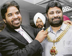 Gloucester mayor Harjit Gill (left) puts his official necklace around the neck of Chandigarh mayor Pardeep Chhabra in Chandigarh on Monday.