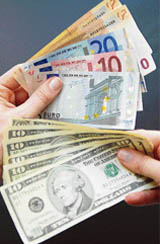 This file photo shows a woman holding several euro and US dollar notes in London