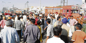 A crowd gathers at Transport Nagar after rioting by slum dwellers in Ludhiana on Wednesday. 