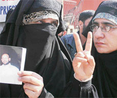 A Kashmiri woman with a photograph of her husband takes part in a sit-in protest in Srinagar on Thursday.