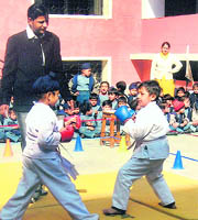 Two kids slug it out during the school karate meet on Thursday.