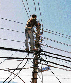 A lineman perched atop a pole repairs the high-tension supply line not caring two hoots for safety measures at lower bazaar in Shimla on Saturday.