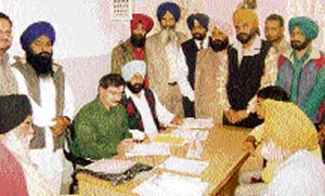 Bikram Jit Singh Khalsa, chief parliamentary secretary, discusses a point with doctors during a medical camp at Ahmedgarh on Sunday. 