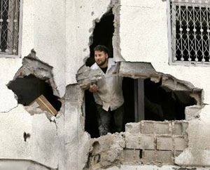 A Palestinian looks out of his damaged house after Israeli troops pulled out of the northern Gaza Strip on Monday.
