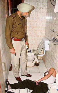 A cop examines the body of Manohar Singh lying in the bathroom of his Sector 23 house on Wednesday.