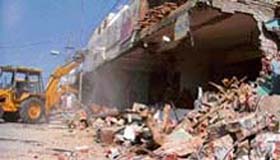 A bulldozer razes shops at Barewal Road in Ludhiana on Wednesday.