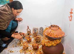 A woman belonging to Kashmiri Pandit community offers prayers during Mahashivratri in Sheikpora in Budgam on Thursday. 