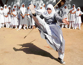Muslim schoolgirl Zeenath Sultana takes part in a martial arts training demonstration at St. Maaz High School in Hyderabad on Friday. Sixty students, encouraged by their parents and school officials, are learning the art of self-defence using sword and sticks during school hours. The world celebrates International Womens Day on March 8.