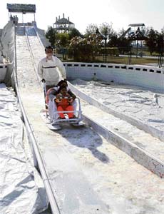 A child enjoys a sledge ride on artificial snow at Fun City, near Chandigarh