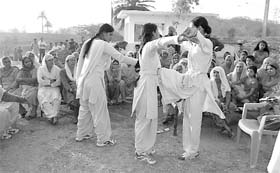 Women police personnel exhibit martial arts at Nadda village on the International Womens Day