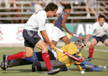 Great Britains Rob Moore (L) eludes Indias goalie Baljit Singh on Sunday during their match for the World Hockey Olympic Qualifying Tournament in Santiago.