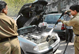Firemen try to douse the flames of a burning car at the parking of the UT Secretariat in Sector 9, Chandigarh, on Tuesday.