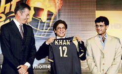 Actor Shah Rukh Khan (C), co-owner of the Kolkata team, displays the team jersey watched by captain Sourav Ganguly (R) and coach John Buchanan during a press meet in Kolkata 