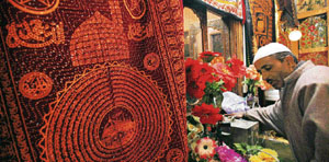 A Kashmiri man touches the shrine of Sufi Saint Khawaja Naqashband on his 344th death anniversary in Srinagar on Wednesday.