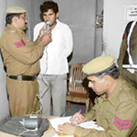 A policeman checks a motorist with an alcohol sensor at the toll plaza in Karnal.