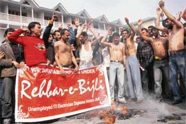 Unemployed ITI electrician diploma holders burn their clothes during a protest against the state government in Srinagar on Thursday