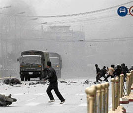 Tibetans throw stones at army vehicles on a street in Lhasa after violent protests on Friday.