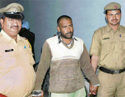 Ratan Singh, who was given life imprisonment for killing his three-year-old son, is taken away by the police in Karnal on Saturday.