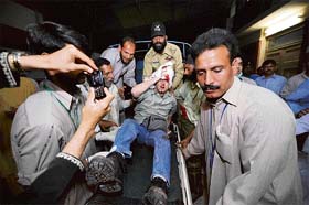 Pakistani volunteers help an injured British diplomat after a bomb blast at a restaurant in Islamabad