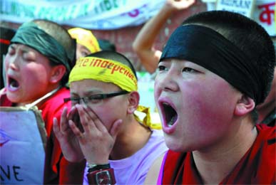 Tibetan demonstrators show solidarity with their countrymen killed by the Chinese troops in Lhasa, near Parliament House in the Capital on Sunday. 