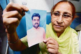 In this file picture Dalbir Kaur shows the photo of her brother Sarabjit Singh
