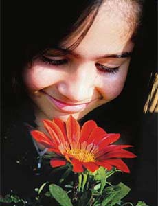 A girl enjoys the fragrance of a flower during the 43rd flower show organised by the Indian Institute of Integrative Medicine (IIIM) in Jammu