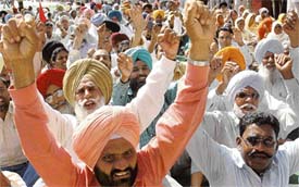 Members of Punjab Mulazim Action Committee, raise slogans against the state government during a protest at Sector 17 Plaza in Chandigarh on Monday