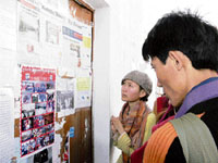 Tibetan refugees scan information boards to get updates on the current situation in Tibet at McLeodganj on Monday.