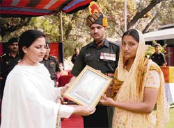 Sukhwinder Kaur, widow of late naik Raghvir Singh who laid down his life fighting militants during Operation Rakhshak in October, 2005, being awarded the Batch of Sacrifice in Jammu on Monday. 