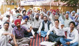 Employees sit on a dharna to protest against Vigilance interference in Ludhiana on Monday.