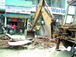 An illegal structure being razed by MC officials in Amritsar on Tuesday. 