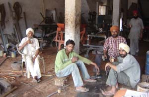 Workers waiting for resumption of power supply in Malout, the hub of agri-tool making small-scale industry.
