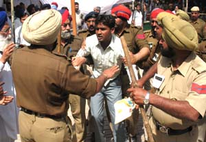 Policemen overpowering Nirmal Singh, who broke the secruity ring to reach Sukhbir Badal in a public meeting at Goniana on Tuesday. 