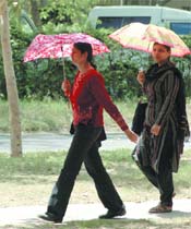 Scalding sunshine forces students to open their umbrellas as the mercury rises in the Capital on Tuesday.