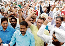 Employees of the Food Corporation of India, Punjab region, shout slogans against authorities during a demonstration at the regional office in Sector 31, Chandigarh, on Wednesday.