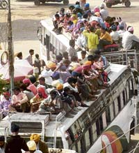 Devotees climb atop private buses in Amritsar on Wednesday to attend Hola Mohalla at Anandpur Sahib.
