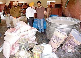Police and senior officials from the health department inspect the synthetic milk found in Rajpura