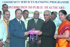 T.K.A. Nair(R), Prinicipal Sec. to the Prime Minister receves a cheque of Rs 17 lakh as donation on behalf of the Arsha dharma Parishad from Gautam Kanjilal(L), chief manager, State Bank of India, Delhi Circle 