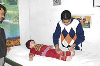 Dr Davinder Singh examines a child at Fatehabad.