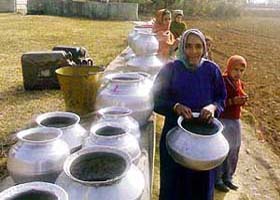 Women fill water from a tanker at Danidhar village near Rajouri