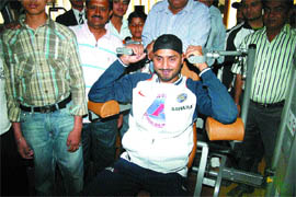Cricketer Harbhajan Singh tries a workout machine at a gym in Jalandhar.